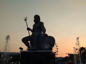 Low angle view of silhouette statue against sky