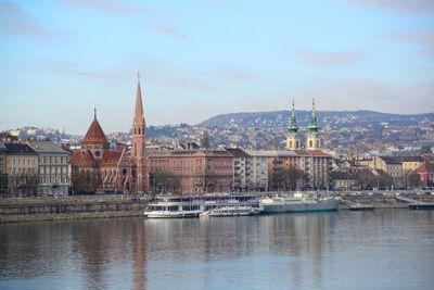 River amidst buildings in city against sky