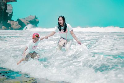 Full length of friends enjoying at sea shore