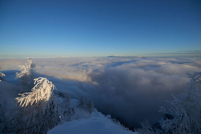 Scenic view of snow covered mountains against blue sky