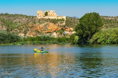 People in river against sky