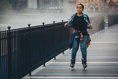 Full length portrait of woman standing on footbridge