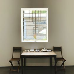 Empty chairs and table against wall at home