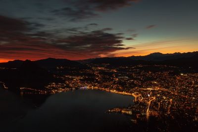 Aerial view of illuminated city against sky at sunset