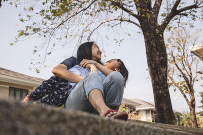 Rear view of mother and daughter on tree