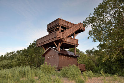 Low angle view of traditional windmill on field against sky