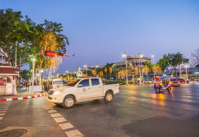 Cars on road in city against clear sky