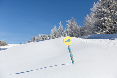 Turn right direction sigh in the snowy forest in austrian alps