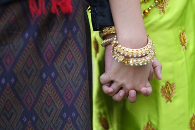 Midsection of women holding hands