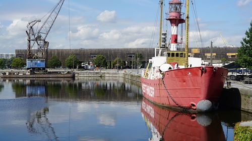 Ship moored at harbor against sky