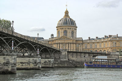 Institut de france by seine river against sky