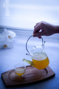 Midsection of person holding drink on table