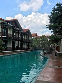 Houses by swimming pool against buildings in city