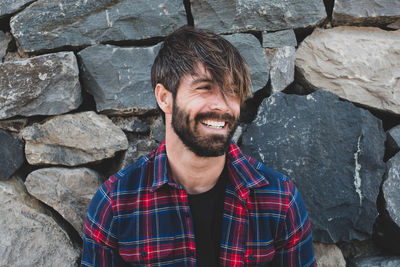 Smiling man looking away while standing outdoors