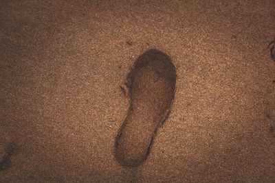 High angle view of shoe print on sand at beach