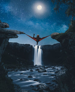 Rear view of man on rock against sky