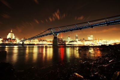 Suspension bridge over river at sunset