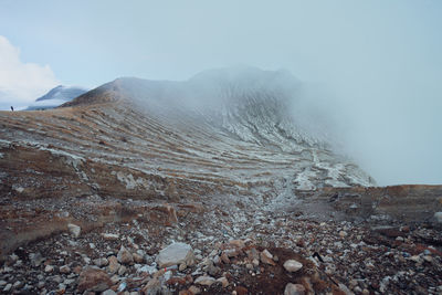 Cloudy gunung kawah ijen mountain sulphur crater scenery in banyuwangi, indonesia.