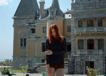 Woman standing against building