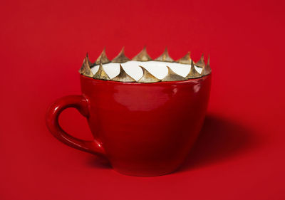 Close-up of coffee cup against red background