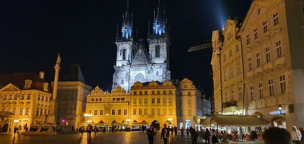 Group of people in front of buildings at night