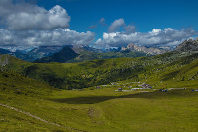 Scenic view of green landscape and mountains against sky