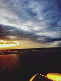 Aerial view of airplane wing against sky during sunset