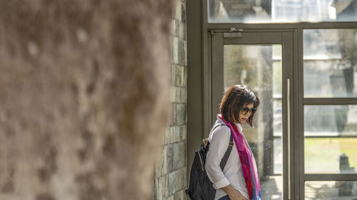 Portrait of woman standing against wall during winter