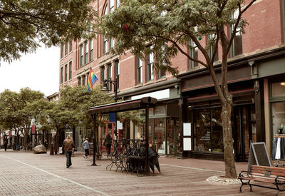 People walking on street amidst buildings in city