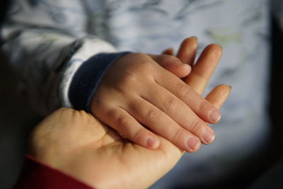 Cropped hand of mother with son