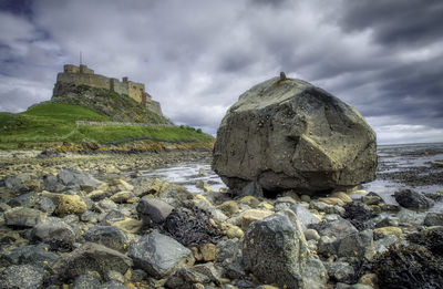 Rocks on sea shore against sky