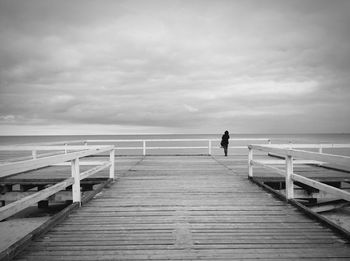 Rear view of man standing on pier