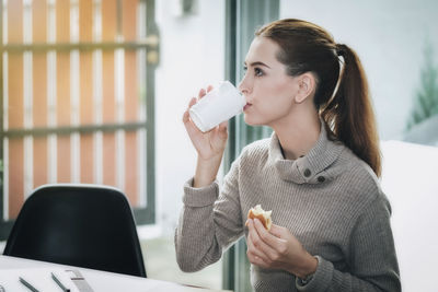 Close-up of young woman holding drink