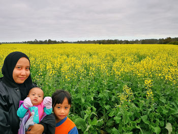 Portrait of woman with children against flowering plants