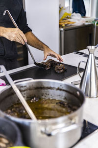 Midsection of person preparing food in kitchen