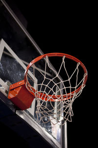 Low angle view of basketball hoop against black background