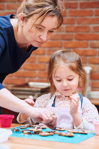 Girl looking at trainer decorating cookies