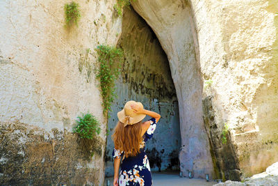 Rear view of woman standing against wall