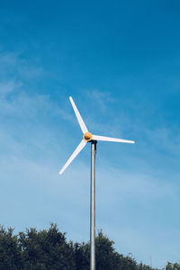 Low angle view of windmill against blue sky