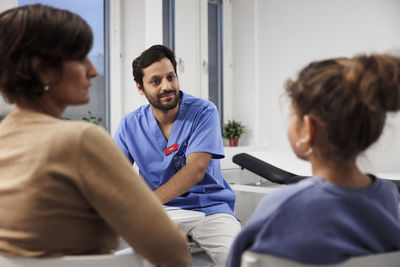 Male doctor talking to mother and daughter during appointment