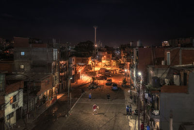Illuminated cityscape against sky at night