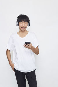 Portrait of smiling man standing against white background