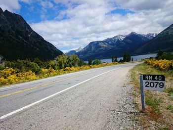 Road by mountains against sky