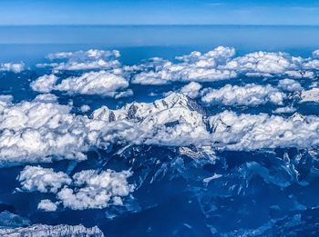 Aerial view of snowcapped landscape against blue sky