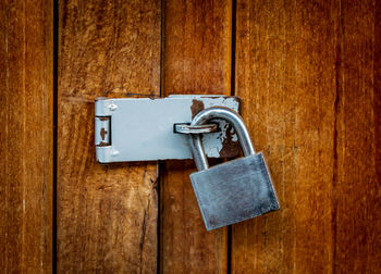 Close-up of padlock on wooden door