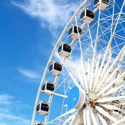 Low angle view of ferris wheel against blue sky