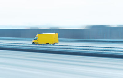 Yellow truck on bridge against clear sky