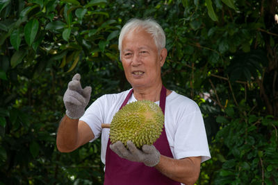 Portrait of man with woman standing against plants