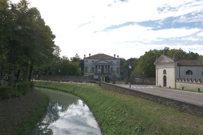 View of lake and buildings against sky