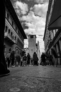 People walking on street amidst buildings in city